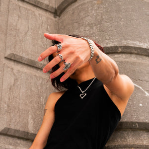 Lifestyle image featuring a hand adorned with three distinct rings: Chain Linked, Prestigious, and the Celtic Cross Ring. The ensemble is complemented by the captivating Venomous Love Chain, creating a stylish and meaningful statement in accessories.